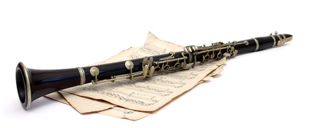 an old clarinet on music sheets over whiteの写真素材