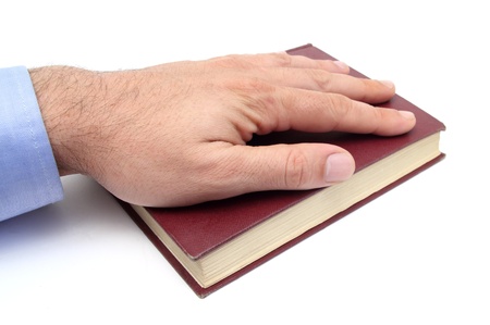 closeup of a hand swearing on a bibleの写真素材