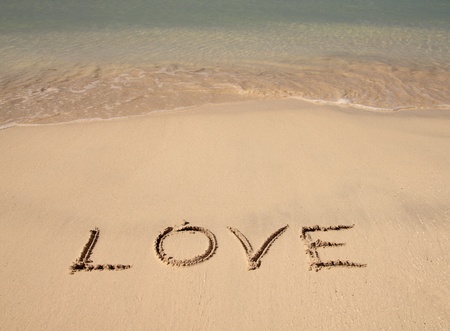 the word love written on the sandの写真素材