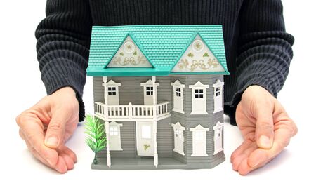 closeup of two hands presenting a little house