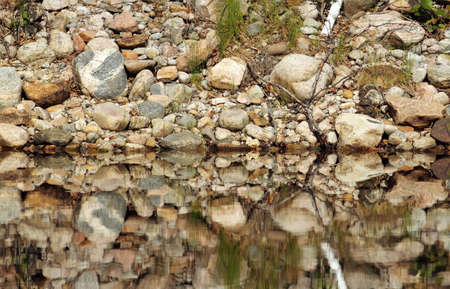 closeup of the shore making a reflection on the waterの写真素材