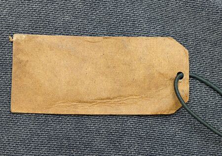 paper price tag with cord over blue fabricの写真素材