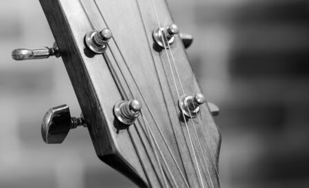 black and white closeup of a wood guitarの写真素材