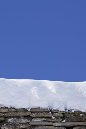 rock structure with snow on it over blue clear skyの写真素材