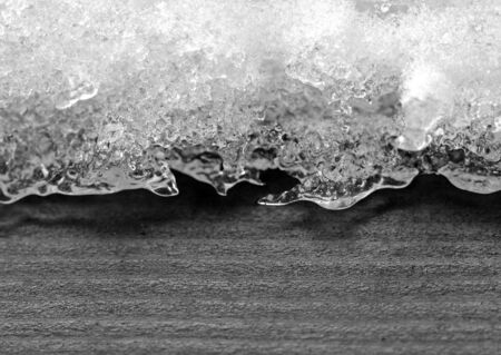 macro of ice and snow over a piece of woodの写真素材