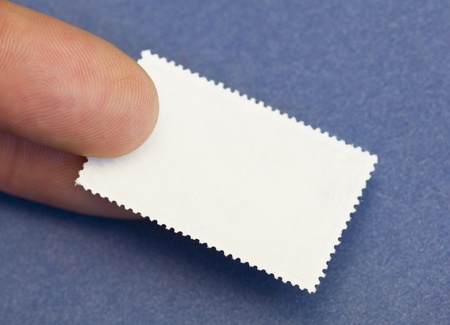 closeup of two fingers holding a blank stampの写真素材