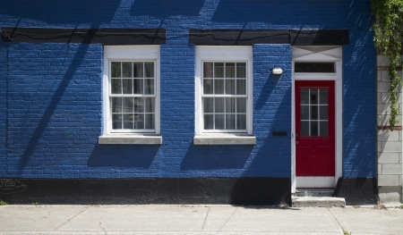 closeup of a blue facade with red doorの写真素材