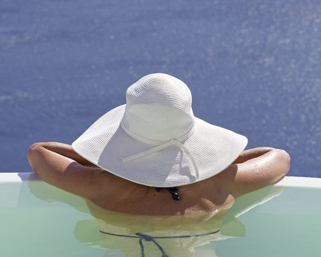 woman watchin the ocean in a private pool on santorini island greeceの写真素材
