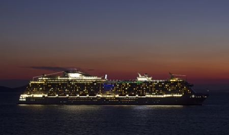big cruise ship with lights open at sunsetの写真素材