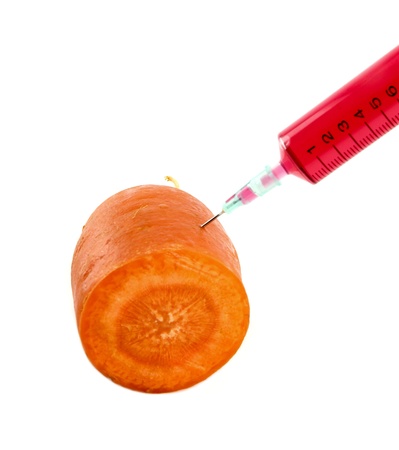 carrot with syringe injected isolated on white backgroundの写真素材