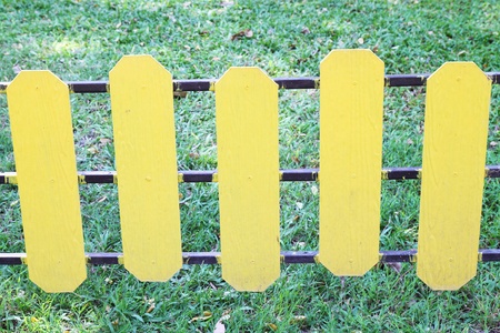 yellow wooden fence on a green meadowの写真素材
