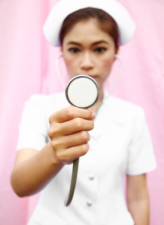 Young nurse with stethoscope chekingの写真素材