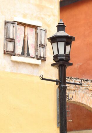 ancient lamppost with vintage window and wall backgroundの写真素材