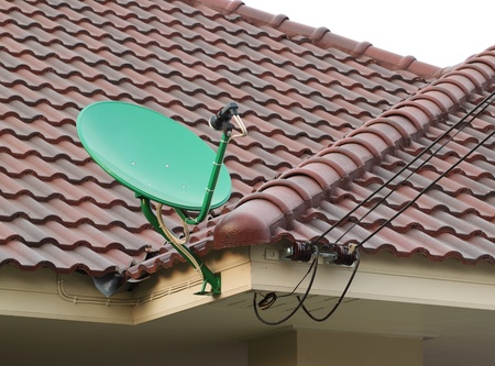 green satellite dish on the roof of tile