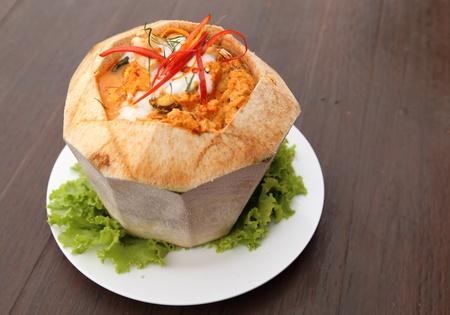 steamed fish and seafood with curry paste in coconut on tableの写真素材