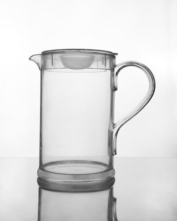 empty glass jug on glass table (gray scale)の写真素材
