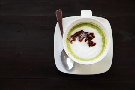 Cup of hot matcha green tea latte with milk creamの写真素材