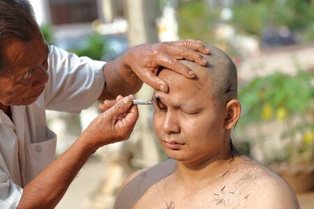 NAKHON RATCHASIMA, THAILAND-APRIL 12: Male who will be monk shaving hair for be Ordained to new monk on April 12, 2015 in the Chae Temple,Nakhon Ratchasima,Thailandのeditorial素材