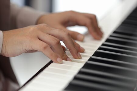 Close up of the hands of a young woman playing pianoの写真素材
