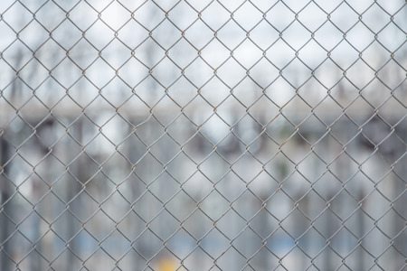 Metal wire fence or cage with blurred backgorund