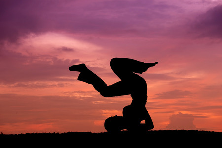 Silhouette of a beautiful Yoga woman at sunsetの写真素材