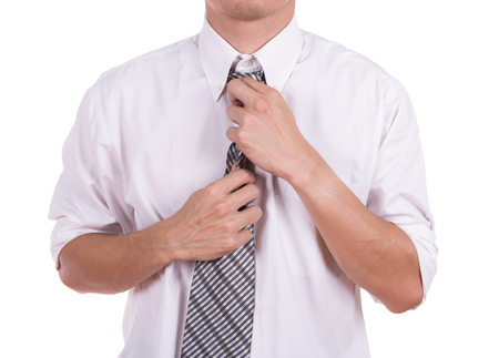 Business man tying the necktie isolated on white backgroundの写真素材