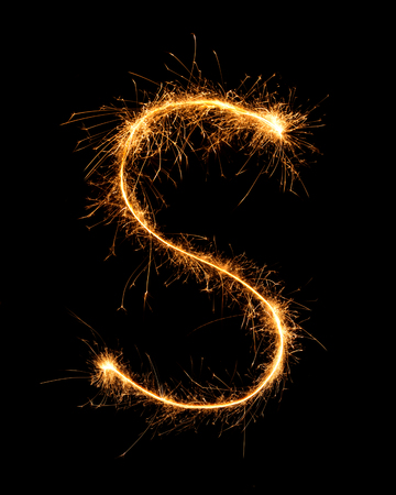 Sparkler firework light alphabet S at night backgroundの写真素材