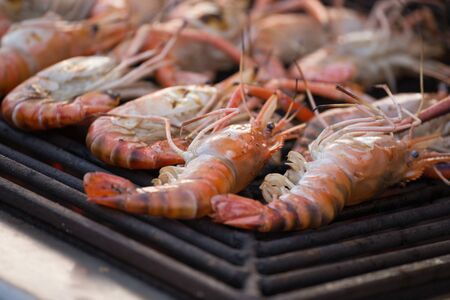 Grilled shrimps seafood by fire and BBQ Flames at marketの写真素材