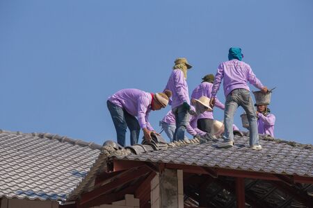 NAKHON RATCHASIMA -FEB 10 : unidentified construction workers installing roof tiles for home building on February 10, 2016 in Nakhon Ratchasima, Thailandのeditorial素材