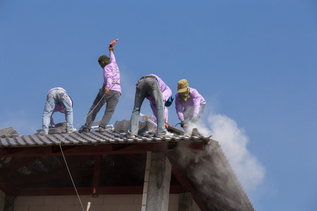 NAKHON RATCHASIMA -FEB 10 : unidentified construction workers installing roof tiles for home building on February 10, 2016 in Nakhon Ratchasima, Thailandのeditorial素材
