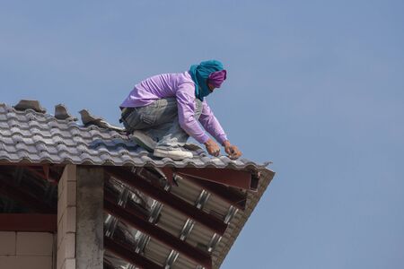 NAKHON RATCHASIMA -FEB 10 : unidentified construction workers installing roof tiles for home building on February 10, 2016 in Nakhon Ratchasima, Thailandのeditorial素材