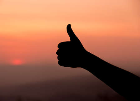 silhouette of Thumb up or like sign at sunsetの写真素材