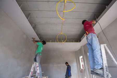 NAKHON RATCHASIMA -MAR 2: unidentified worker installing gypsum board ceiling of building house construction on March 2, 2016 in Nakhon Ratchasima, Thailandのeditorial素材