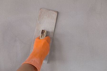 hand of worker use trowel plastering concrete at wallの写真素材