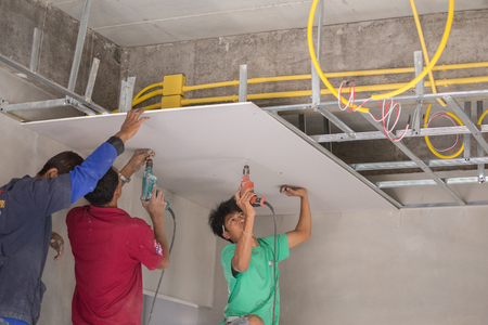 NAKHON RATCHASIMA -MAR 2: unidentified worker installing gypsum board ceiling of building house construction on March 2, 2016 in Nakhon Ratchasima, Thailandのeditorial素材