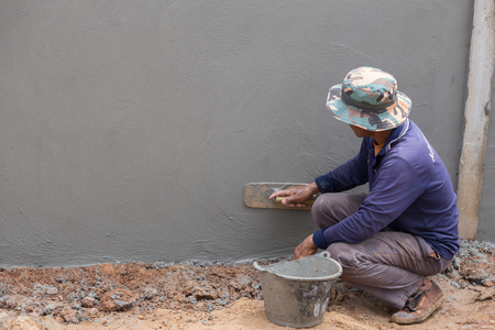 NAKHON RATCHASIMA -JUNE 21 : worker use trowel plastering concrete at wall on June 21, 2016 in Nakhon Ratchasima, Thailandのeditorial素材
