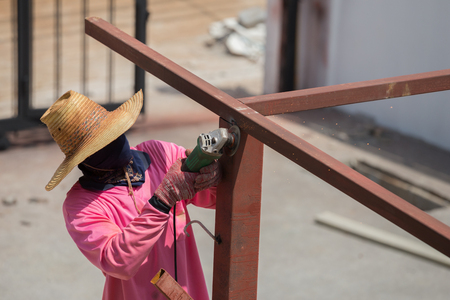 worker using an angle grinder to grinding metalの写真素材