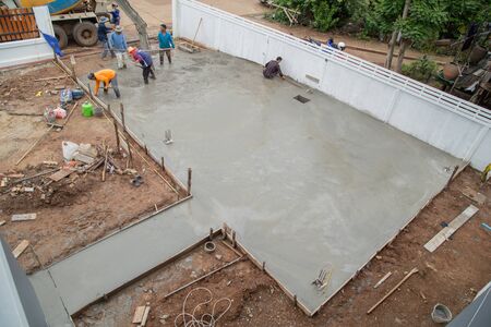 NAKHON RATCHASIMA -JULY 6 : A cement truck and worker are pouring cement to new floor at construction site on July 6, 2016 in Nakhon Ratchasima, Thailandのeditorial素材