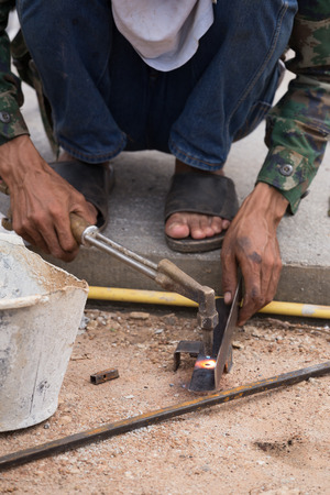 worker drilling steel plate at construction siteの写真素材