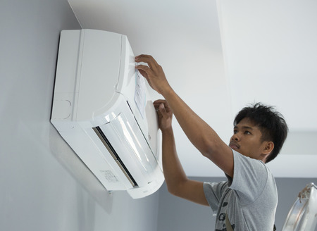 NAKHON RATCHASIMA -JULY 5 : Worker installing air conditioning unit on July 5, 2016 in Nakhon Ratchasima, Thailandのeditorial素材