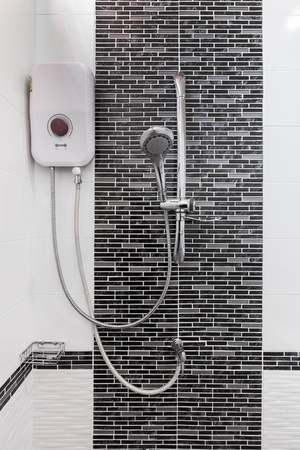 shower and water heater on wall in bathroomの写真素材