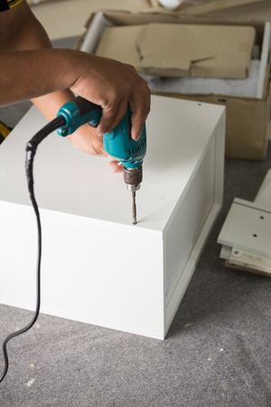 Assembling new furniture with a screwdriverの写真素材