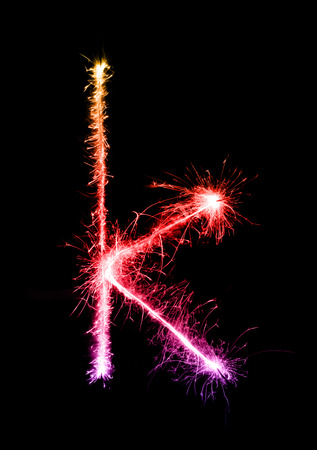 Sparkler firework light alphabet k (Small Letters) at night backgroundの写真素材