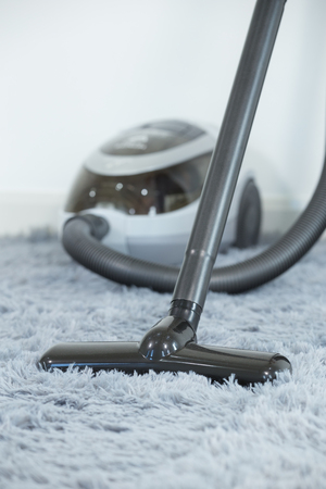 closed-up cleaning carpet floor with vacuum cleaner in the living roomの写真素材