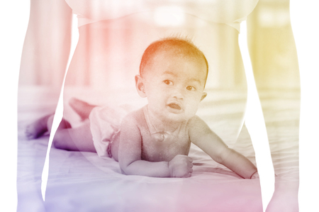 Double exposure of baby with belly of pregmant woman isolated on white backgroundの写真素材