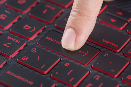 finger pushing enter button on a laptop keyboardの写真素材