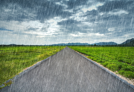 country road with falling rainの写真素材