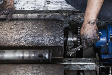 Hand of repairman holding a wrench and tighten and during maintenance work of machineの写真素材