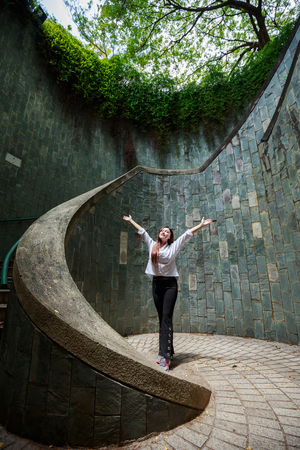 Woman hands up at underground crossing in tunnel at Fort Canning Park, Singaporeのeditorial素材