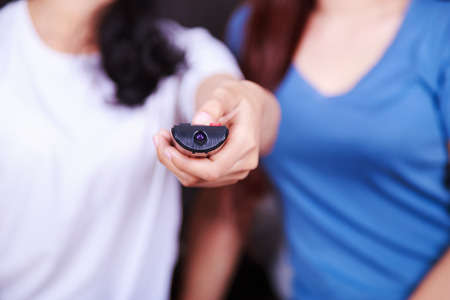 close up of remote tv in hand of woman